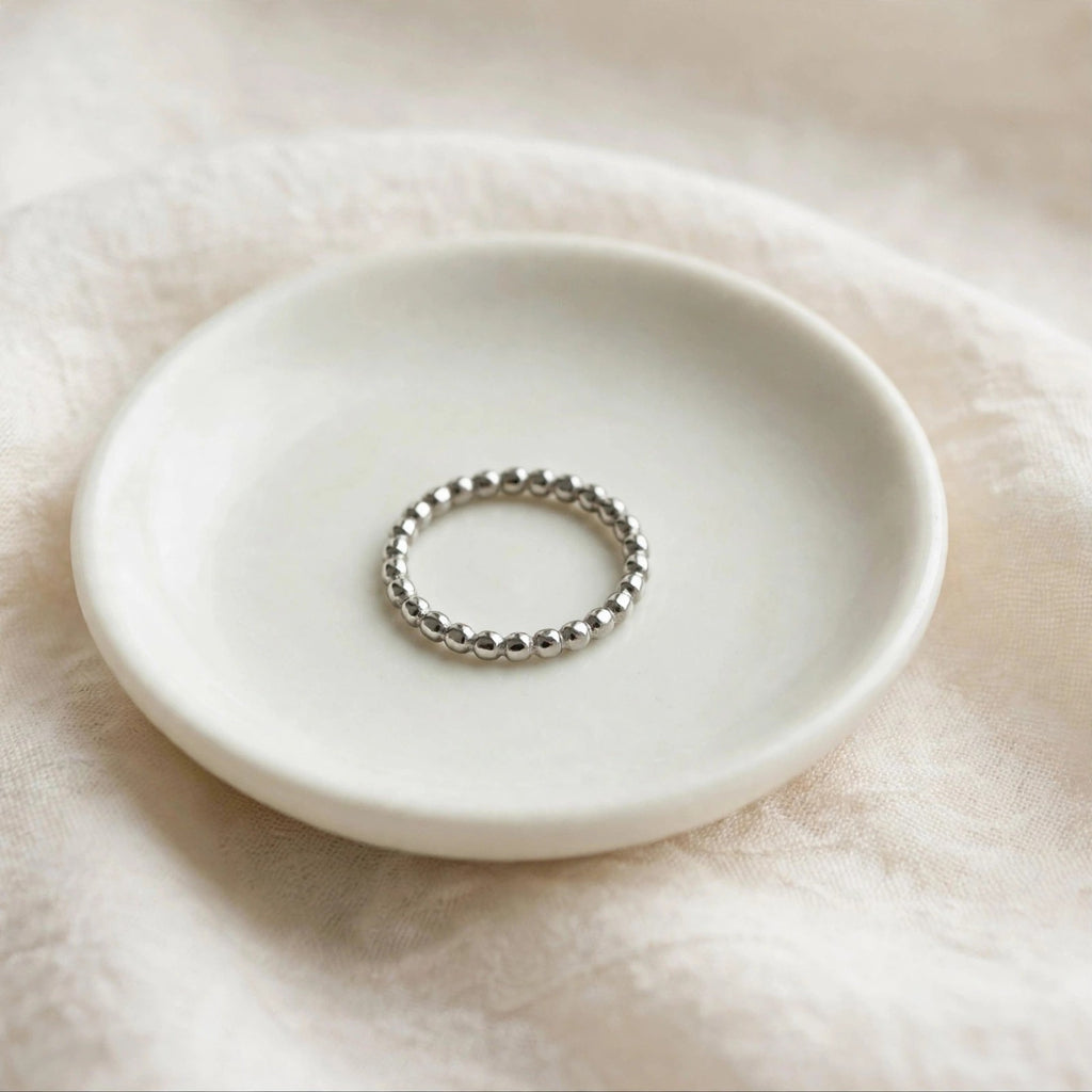 Beaded Spacer Ring in polished stainless steel on a ceramic dish