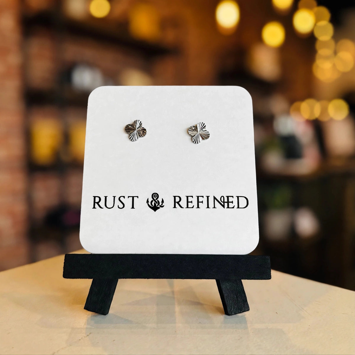 Silver flower stud earrings on a Rust & Refined card