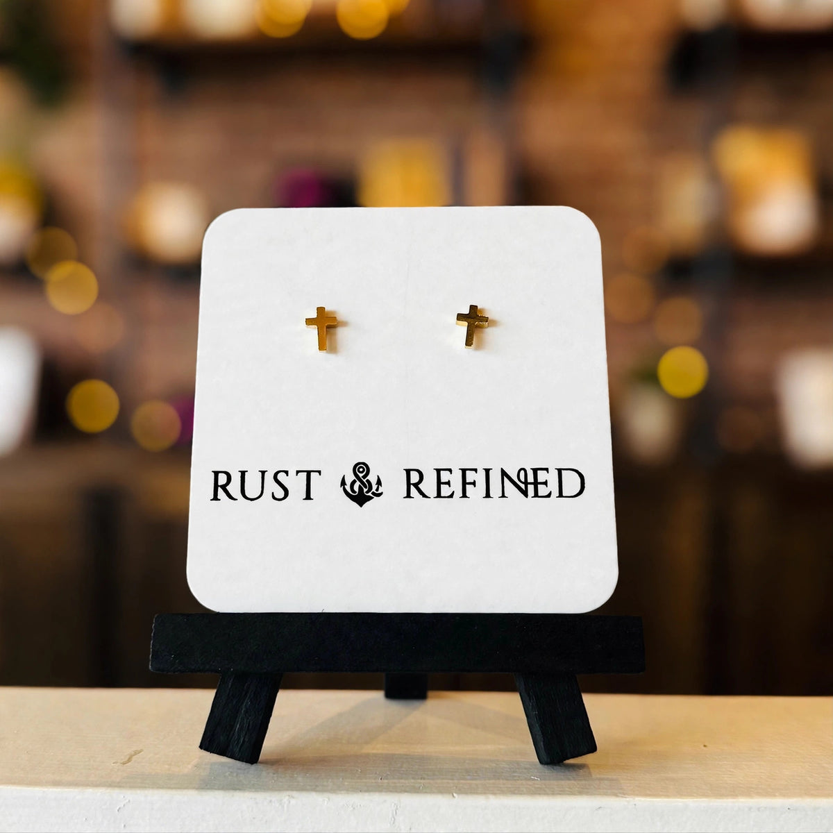 Gold cross stud earrings on a Rust & Refined card