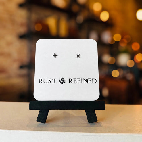 Silver plus and X stud earrings on a Rust & Refined card
