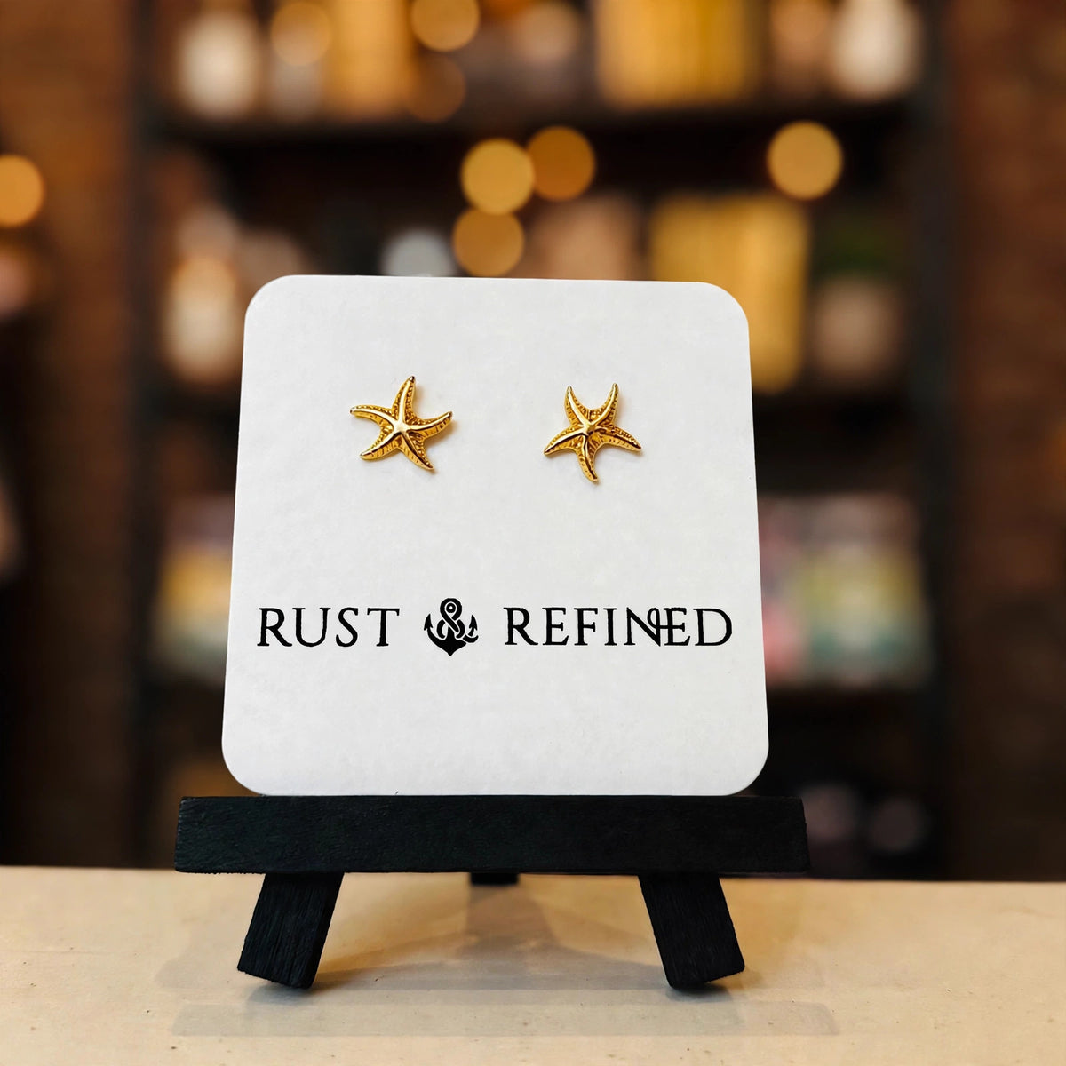 Gold starfish stud earrings on a Rust & Refined card