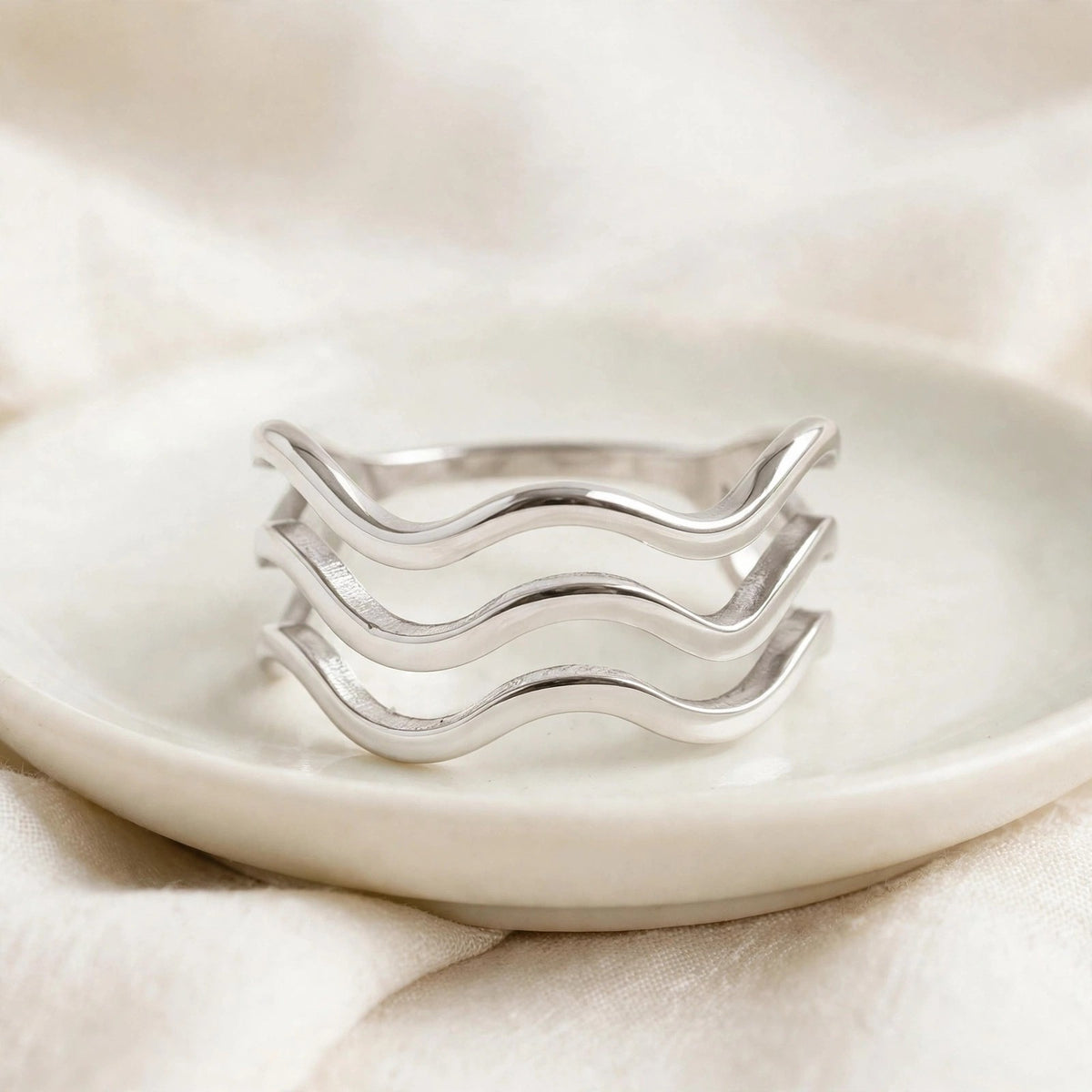 Triple Wave Ring in polished stainless steel on a ceramic dish