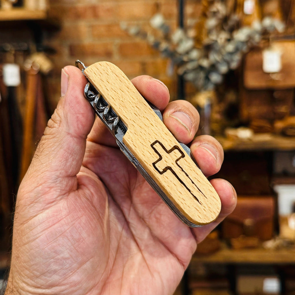 Cross Engraved Pocket Knife held in hand for scale