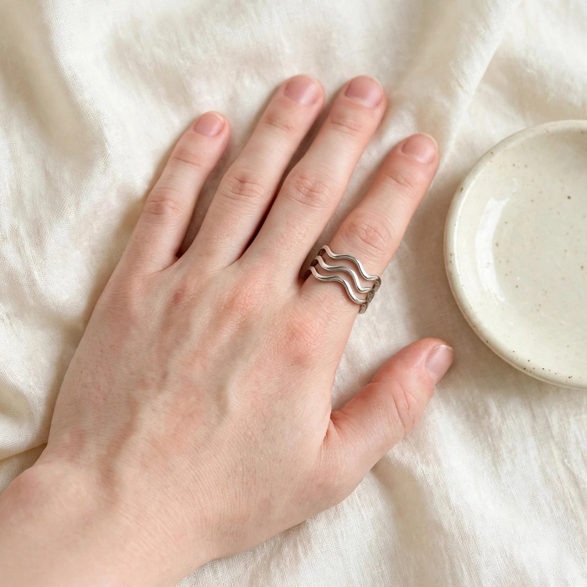 Triple Wave Ring in polished stainless steel worn on a woman's hand
