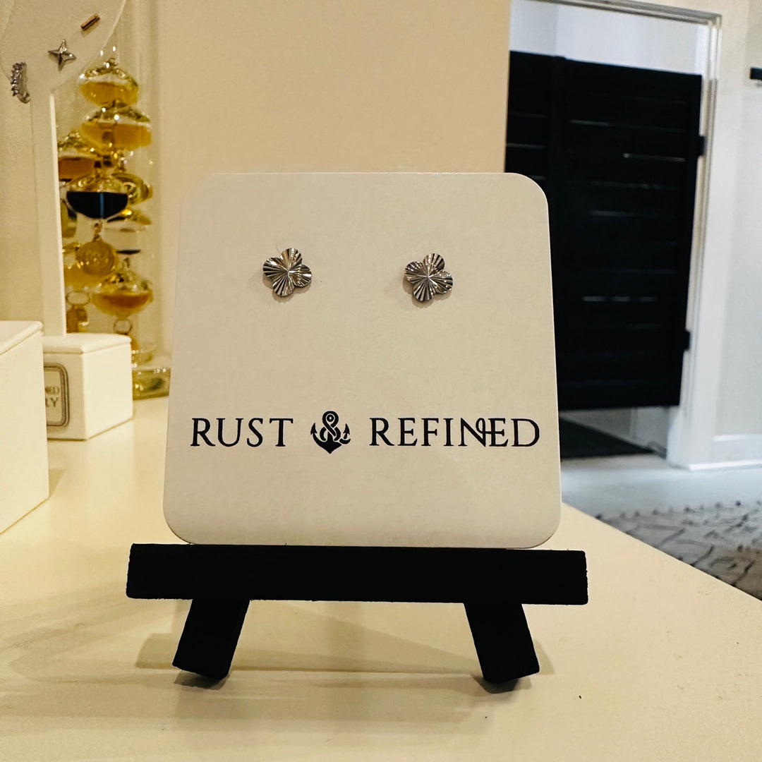 Silver flower stud earrings on Rust and Refined card