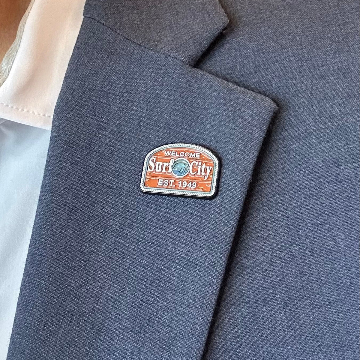 Blue blazer with a visible brand logo on a blurred indoor background