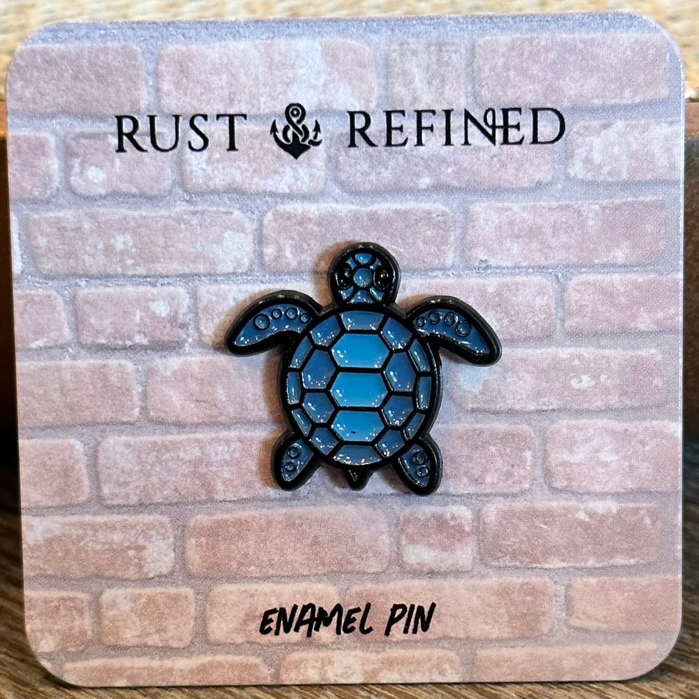 Blue turtle enamel pin on a 'Rust & Refined' branded card with a brick pattern.