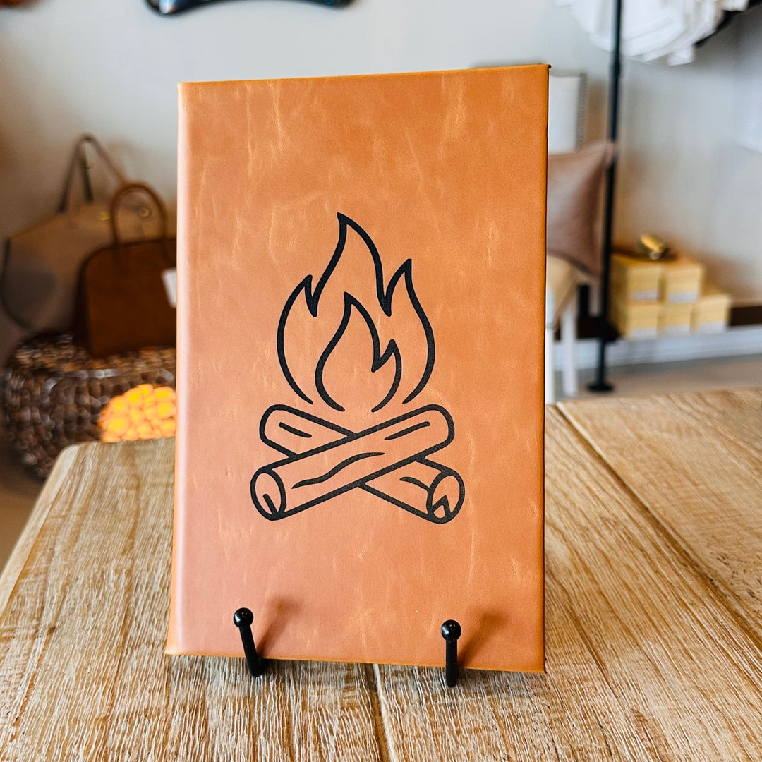 Tan journal with engraved campfire line art
