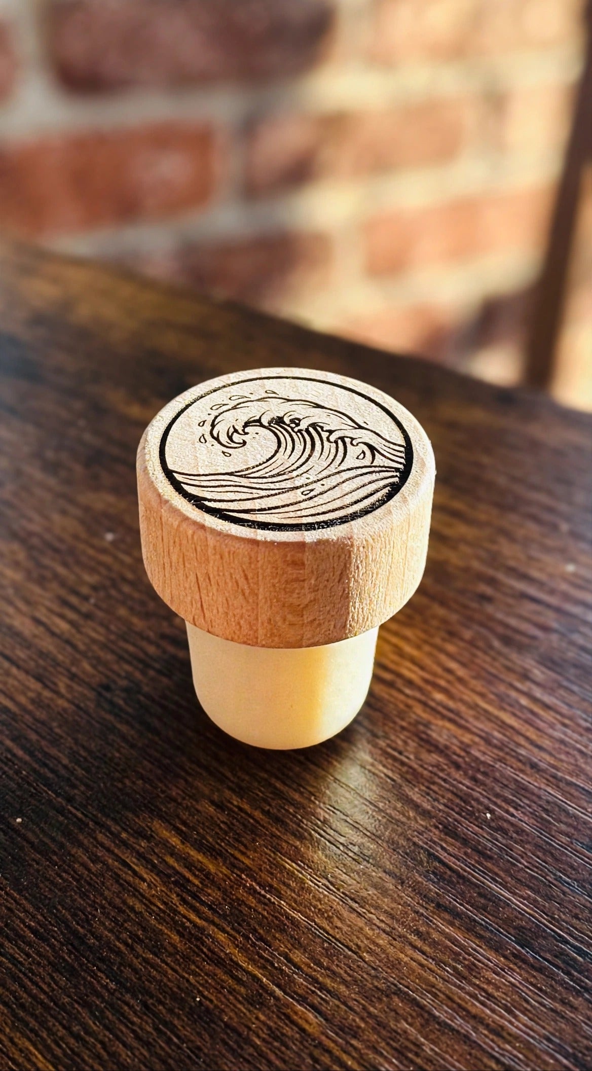 Wave Wine Stopper on a dark wood counter