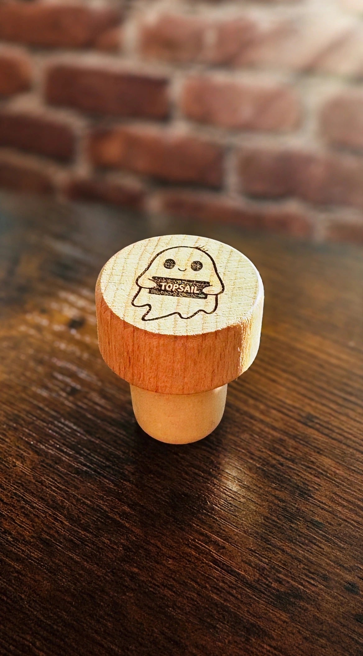 Topsail Ghost Wine Stopper on a dark wood counter