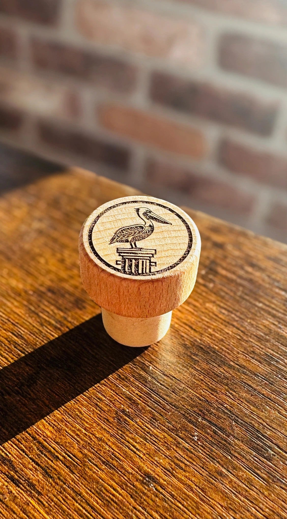 Pelican Wine Stopper on a dark wood counter