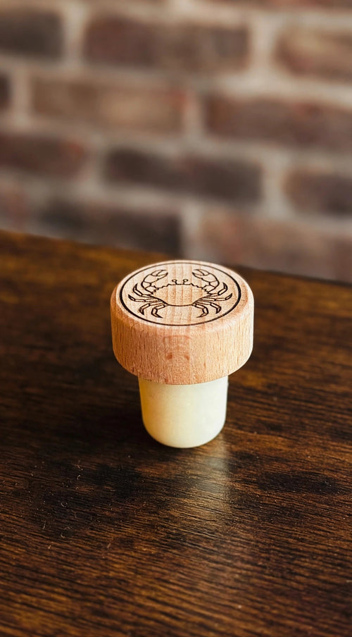 Blue Crab Wine Stopper on a dark wood counter