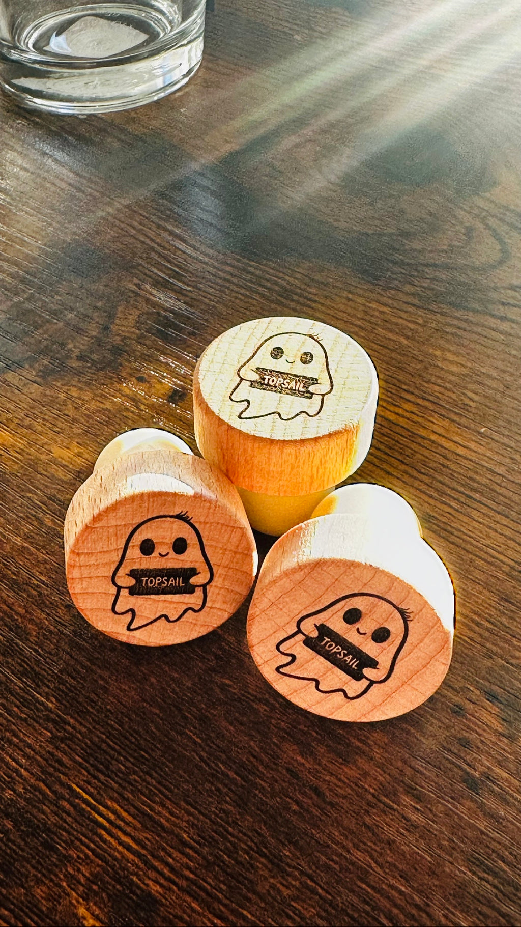 Topsail Ghost Wine Stopper, engraved wood stoppers on a dark wood counter