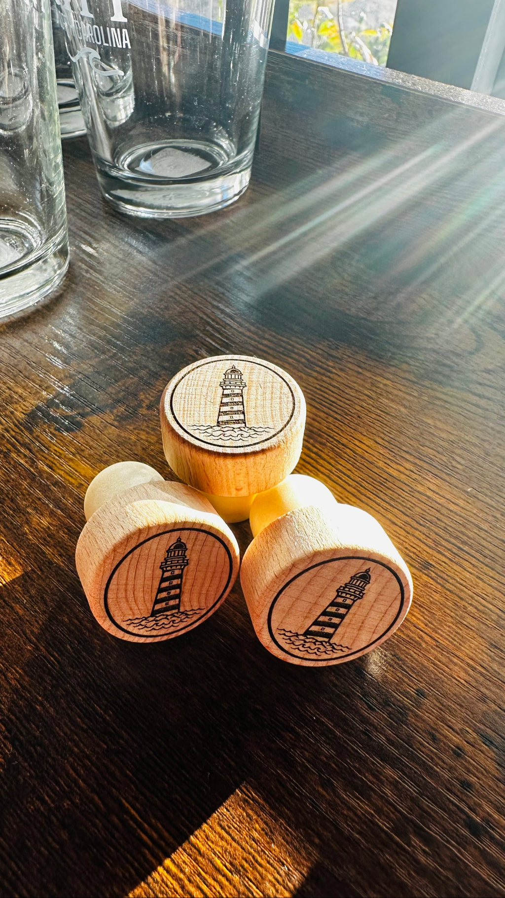 Lighthouse Wine Stopper, engraved wood stoppers on a dark wood counter