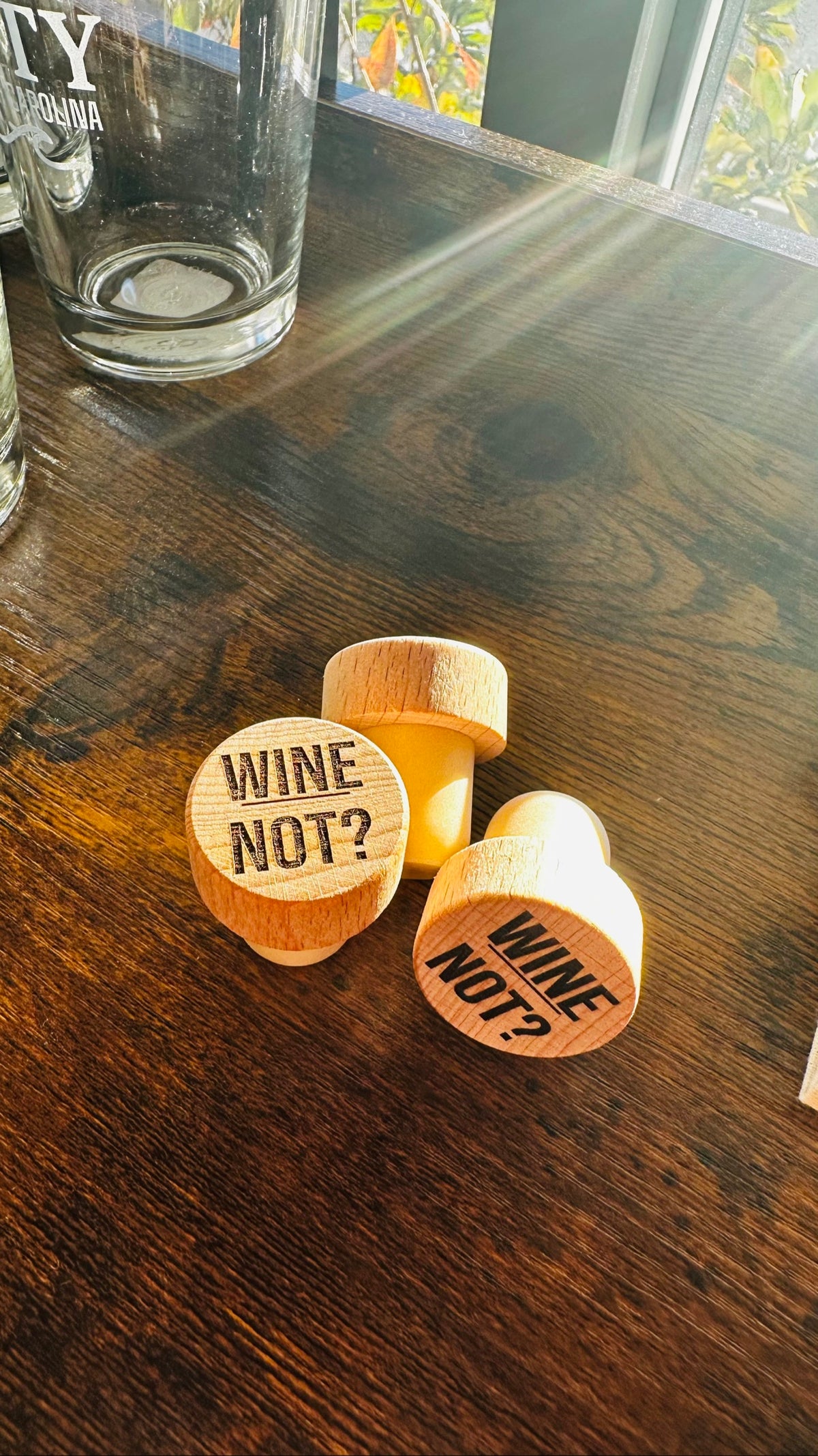 Wine Not? Wine Stopper, engraved wood stoppers on a dark wood counter