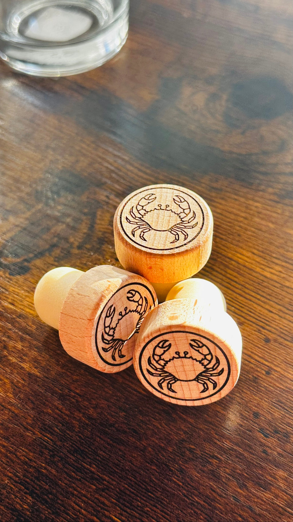 Blue Crab Wine Stopper, engraved wood stoppers on a dark wood counter