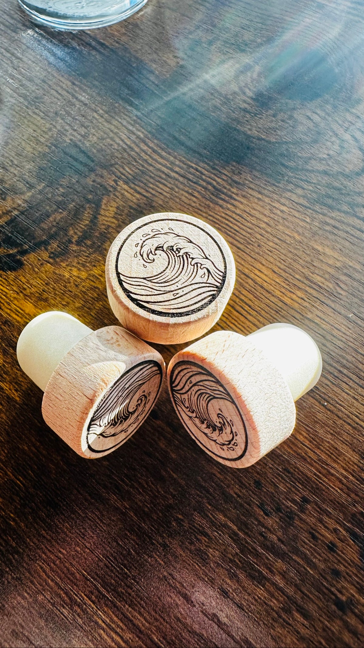 Wave Wine Stopper, engraved wood stoppers on a dark wood counter