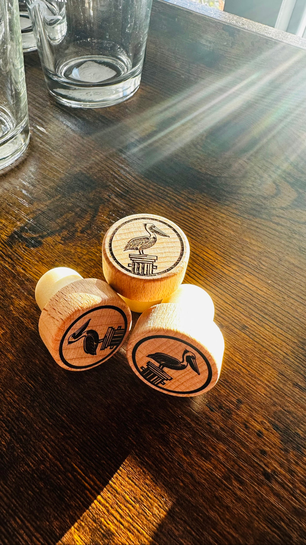 Pelican Wine Stopper, engraved wood stoppers on a dark wood counter